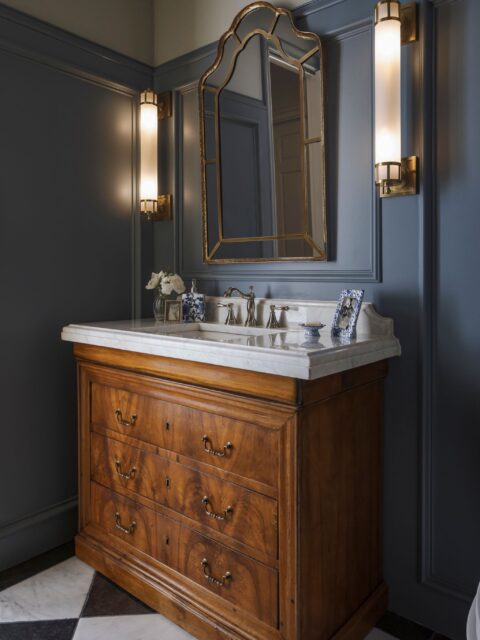 Slate walls, brass sconces, and a dresser-turned-vanity. #ProjectParkviewProper powder room does a lot with a small footprint.